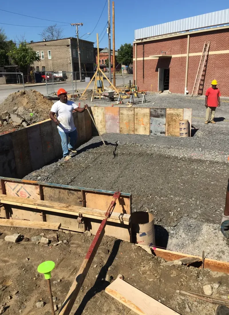 Sanders and Sons crew pouring and finishing a concrete pad in DFW